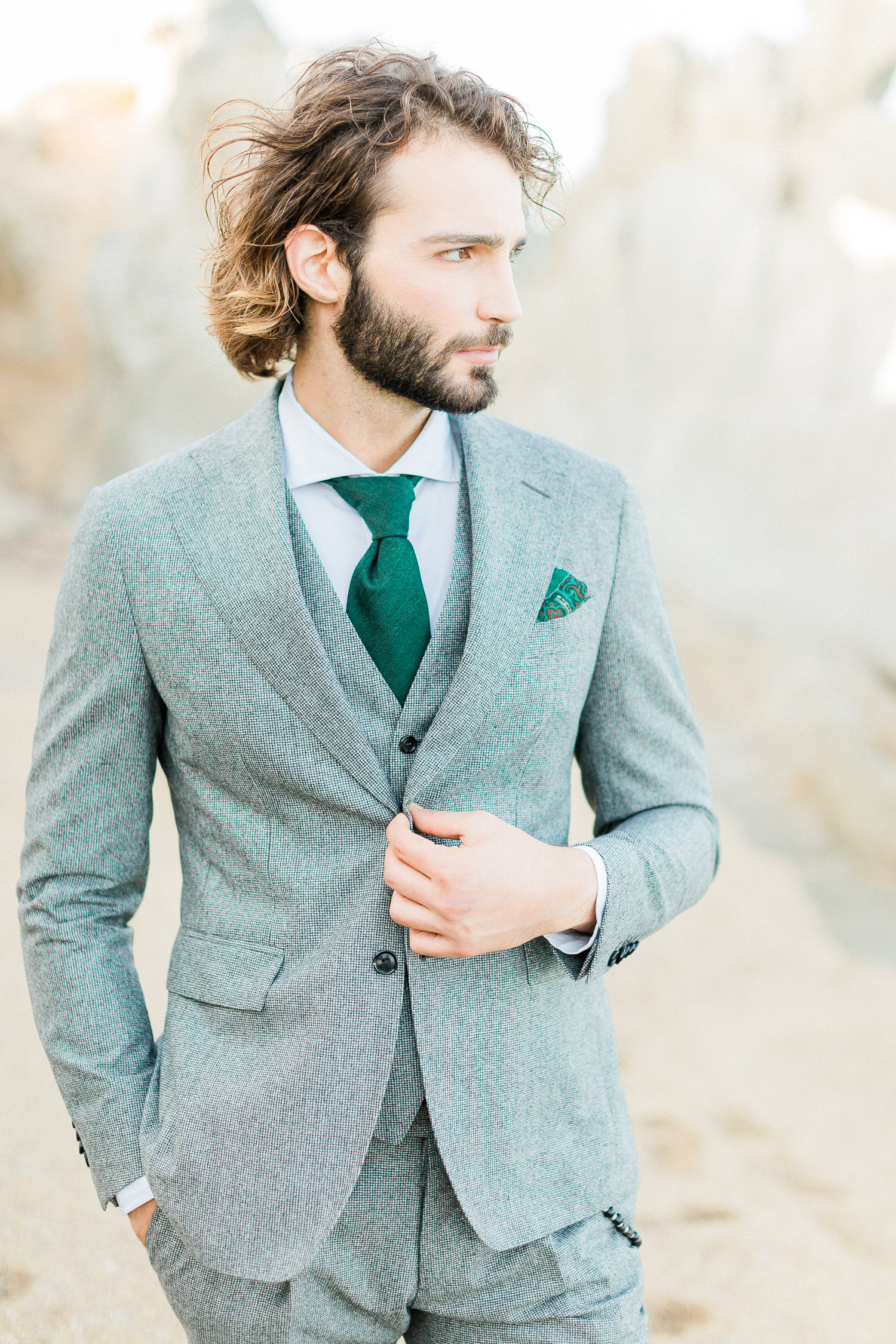a stylish groom wearing grey tuxedo with green details