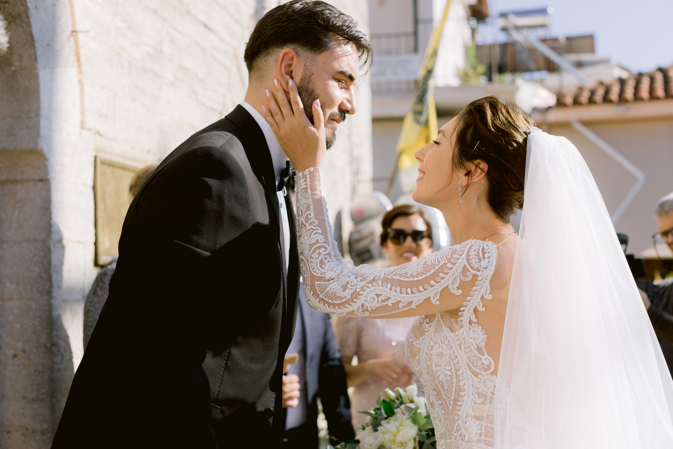 Bride and groom first kiss before wedding ceremony in Greece