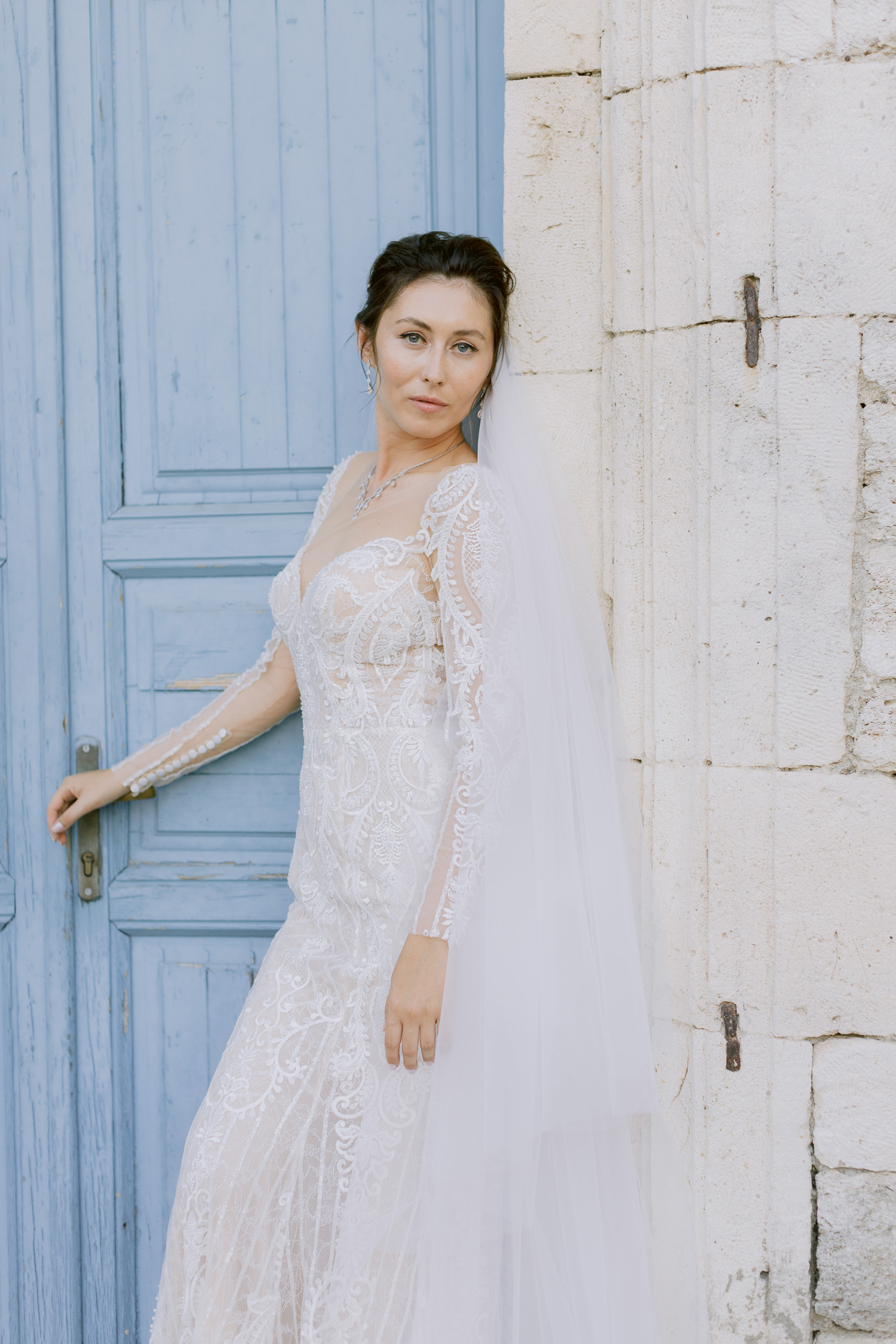 Blue eyes bride posing next to a classical greek architecture building at a micro wedding in Halkidiki